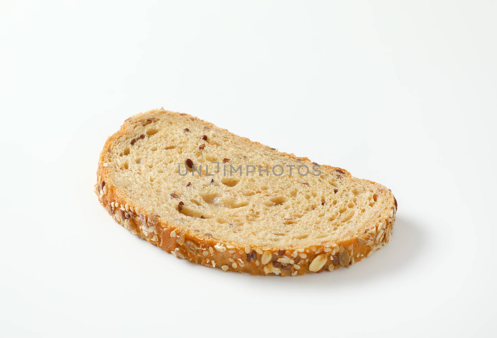 Slice of whole grain bread, crust topped with rolled oats and seeds (flax, sesame, sunflower)