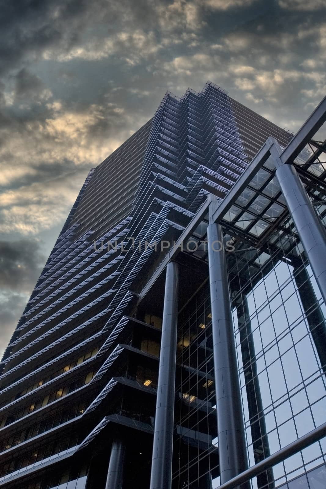 A modern black office tower isolated on Stormy Dusk