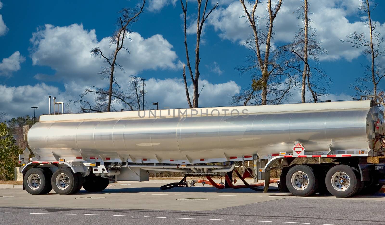 A tanker truck dispensing fuel at a gasoline station