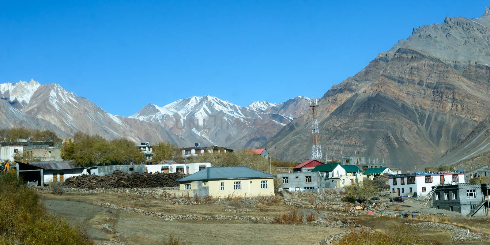 Village at Foothill of Himalayas. Small Villages In The Foothills Of Himalayan picturesque valley. A beautiful indian landscape of a town city at foothills of snow capped Mountain ranges. Kaza India by sudiptabhowmick