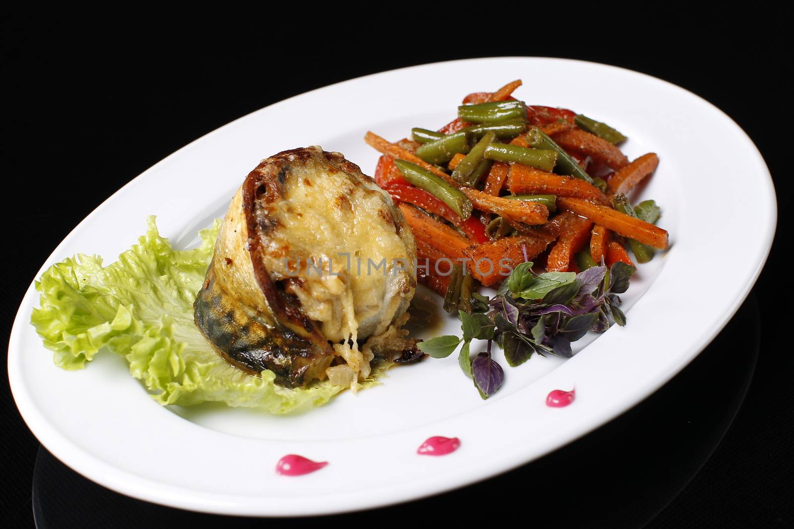 Food on a plate. Fried meat, Korean carrots, seasoning, mayonnaise, sauce, lettuce leaf and dill.Fish on a plate. Cooked mackerel