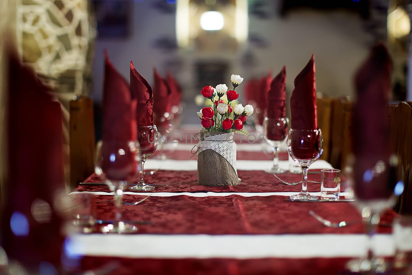 The restaurant .Empty restaurant. Table setting. Prepare for a banquet. Festive table.s a long table served, tablecloths and a bouquet of flowers on the table.