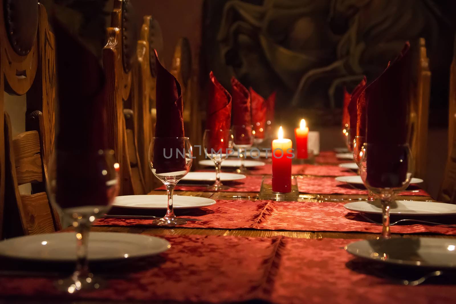 The restaurant has a rich wooden table, claret tablecloths, wooden expensive chairs, candles on the table, glasses.Cheap cafe. Dinner table. Empty restaurant.