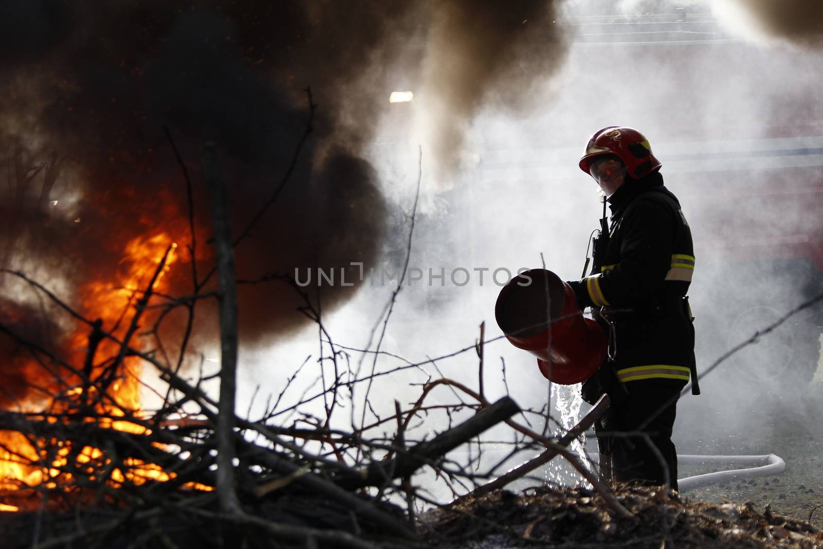 The fireman extinguishes with a foam forest fire.The brave firefighter. Forest fire. Fight fire