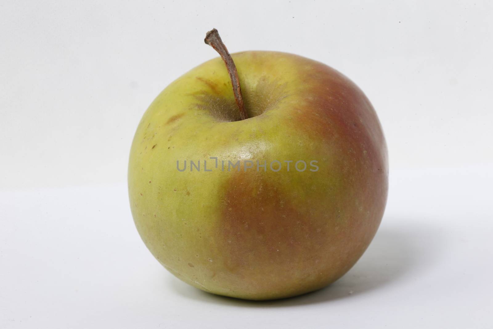 Apple red and green on a white background.The usual apple. A garden fruit. Natural fruit. Food for Adam and Eve. Fruit from paradise