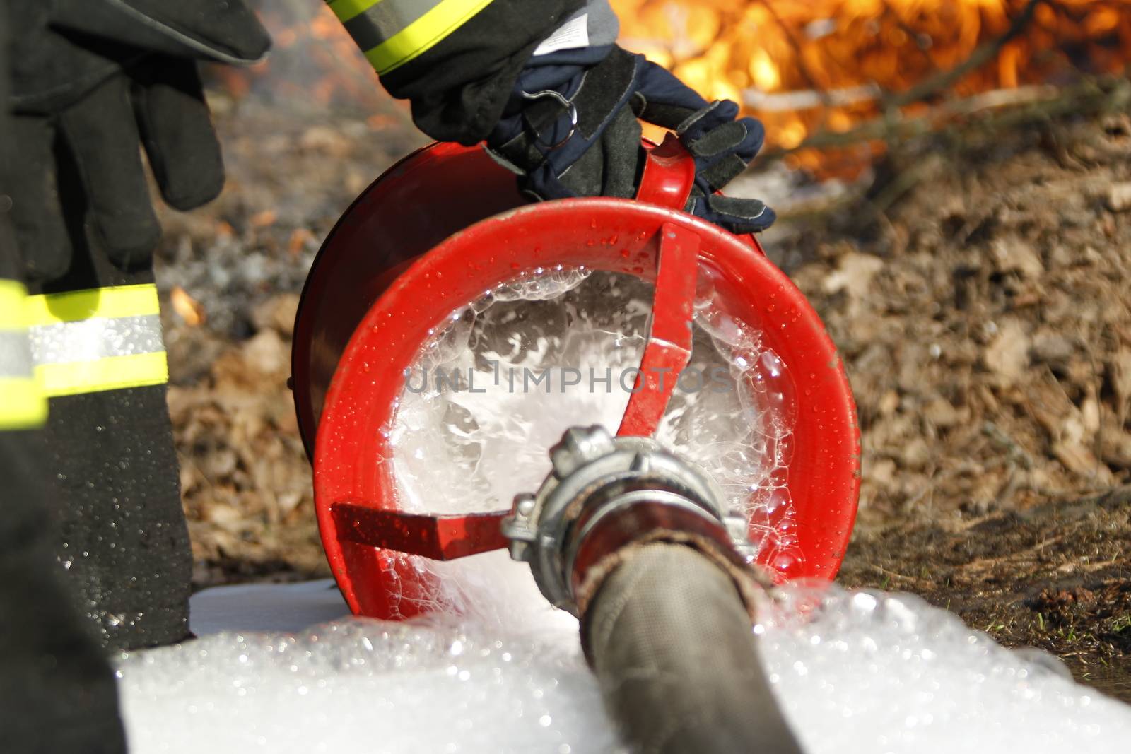 The fireman's hand holds a fire hose to extinguish a fire.Extinguish the fire. Fire hose