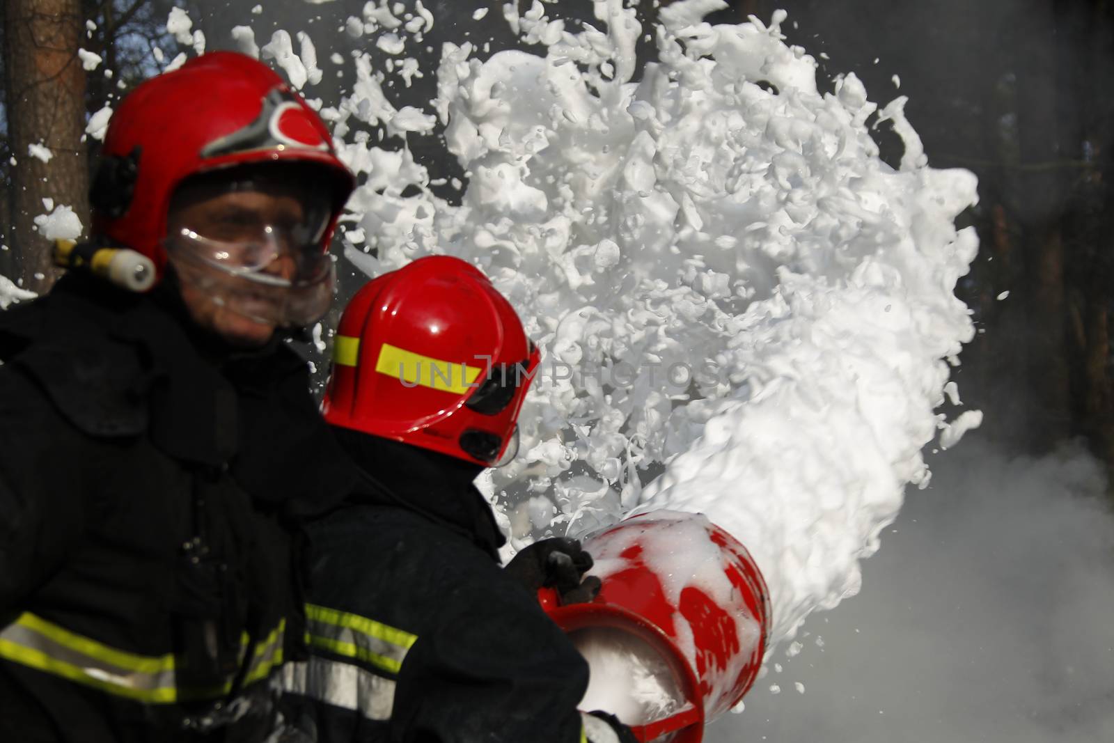 Extinguishing the fire.  Fill the foam with a fire. Resolute firefighters.