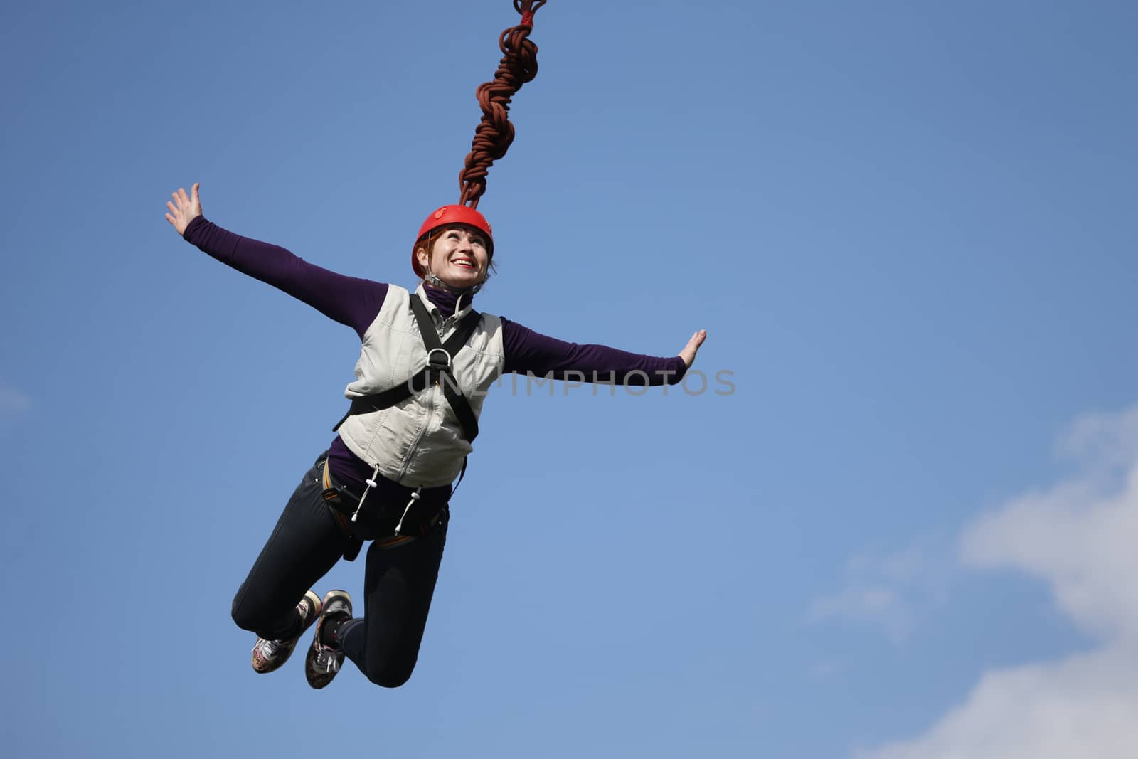 Bold woman jumping with a roped .Crazy hobby of an elderly woman