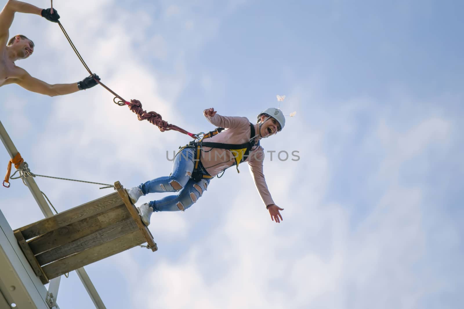 Flight down on the rope.Engage in ropejumpThe brave girl jumped from the bridge and flies in the sky.ing.Dangerous hobbies