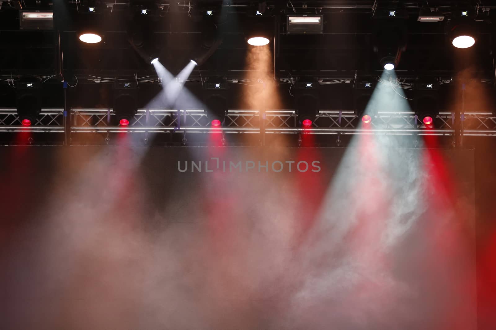 Concert spotlights.Concert spotlights.Red and white rays of powerful projectors on stage