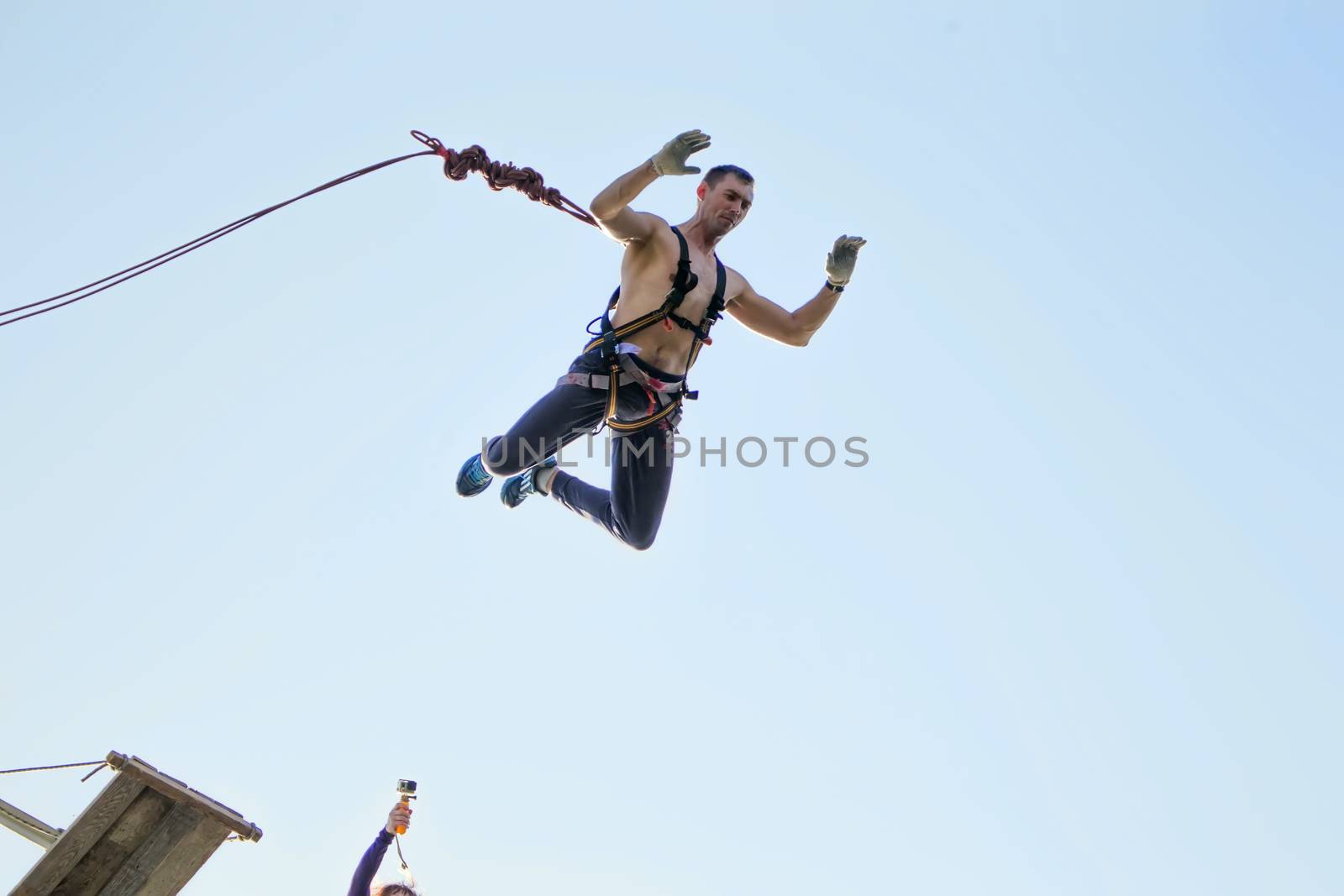 Jumping with a rope.The extreme guy jumped from a huge height.Ropejumping.