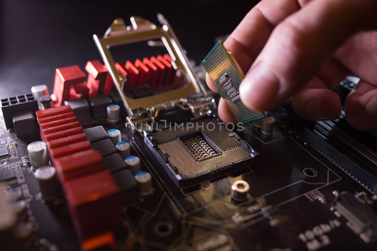 Technician plug in CPU microprocessor to motherboard socket. Workshop background