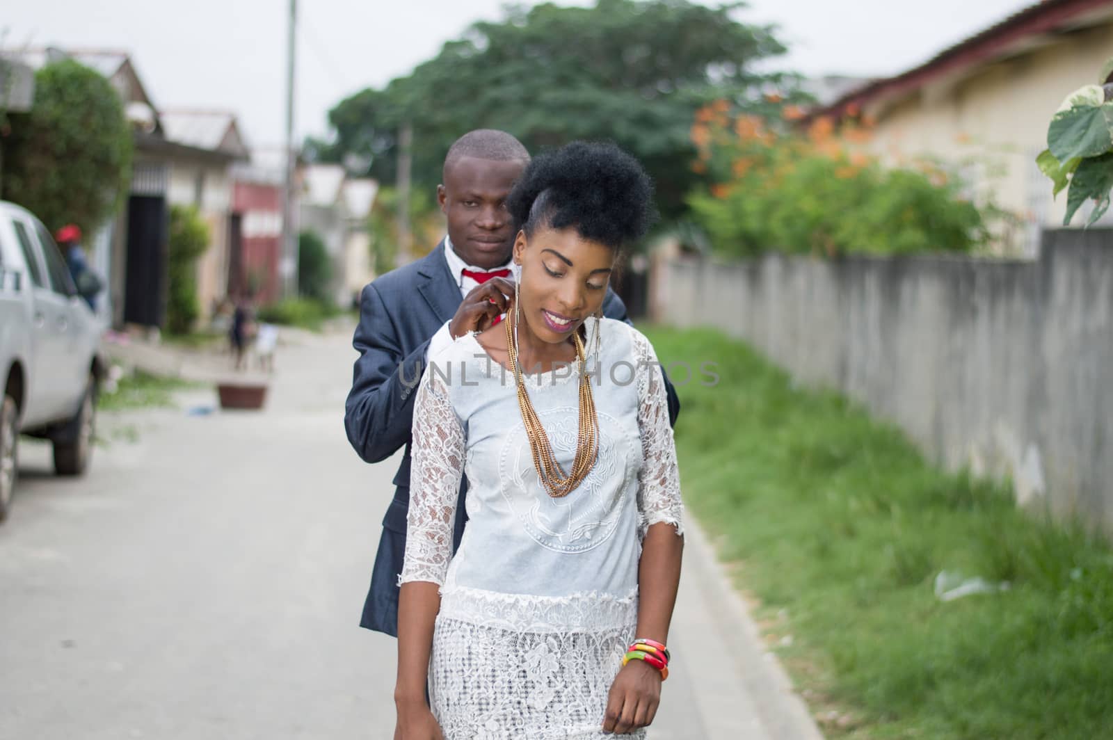 Young man in a suit carrying the chain to his wife outside.