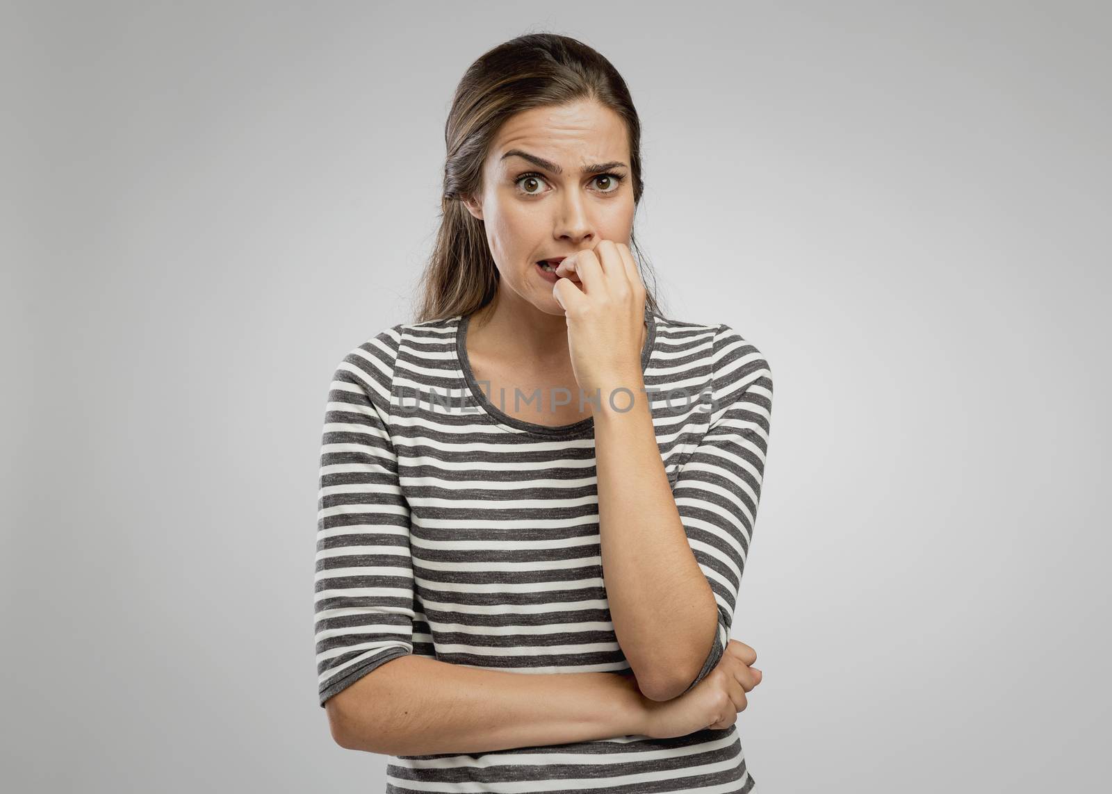 Portrait of a worried woman biting her nails