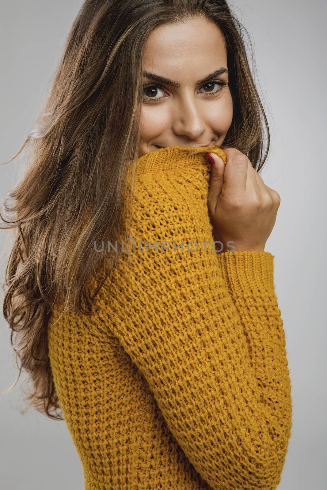 Portrait of a beautiful young woman over a gray background