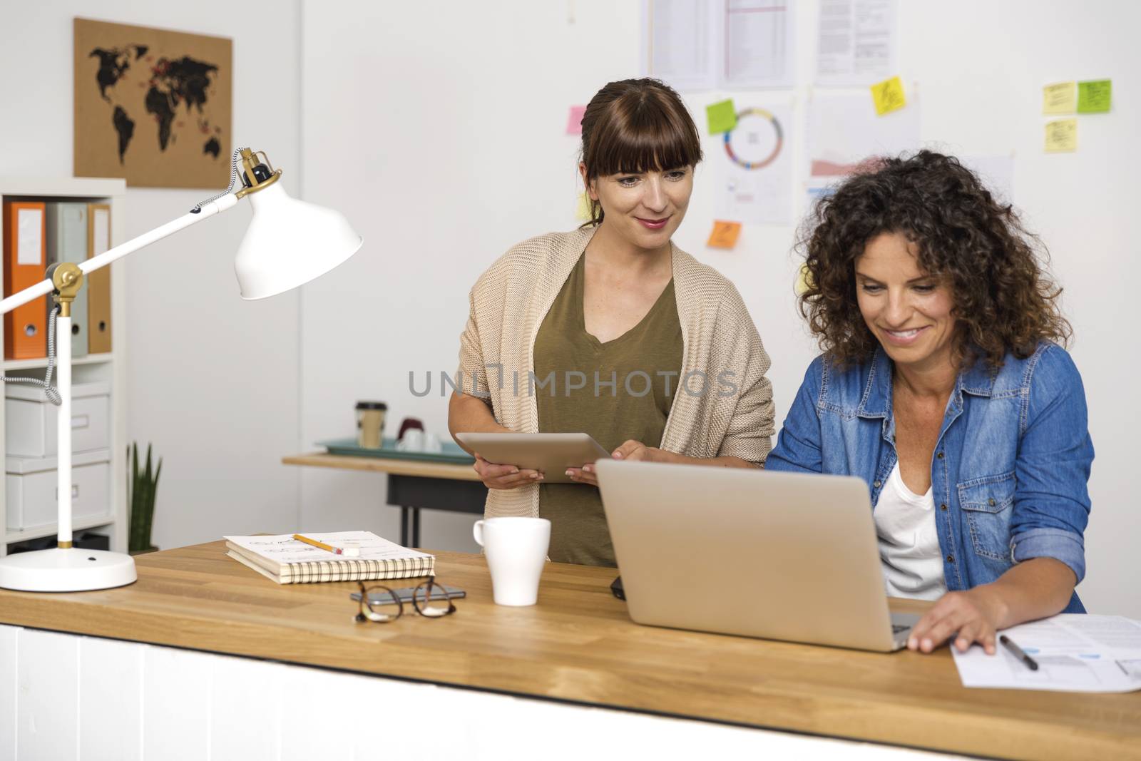 Two businesswoman working together by Iko
