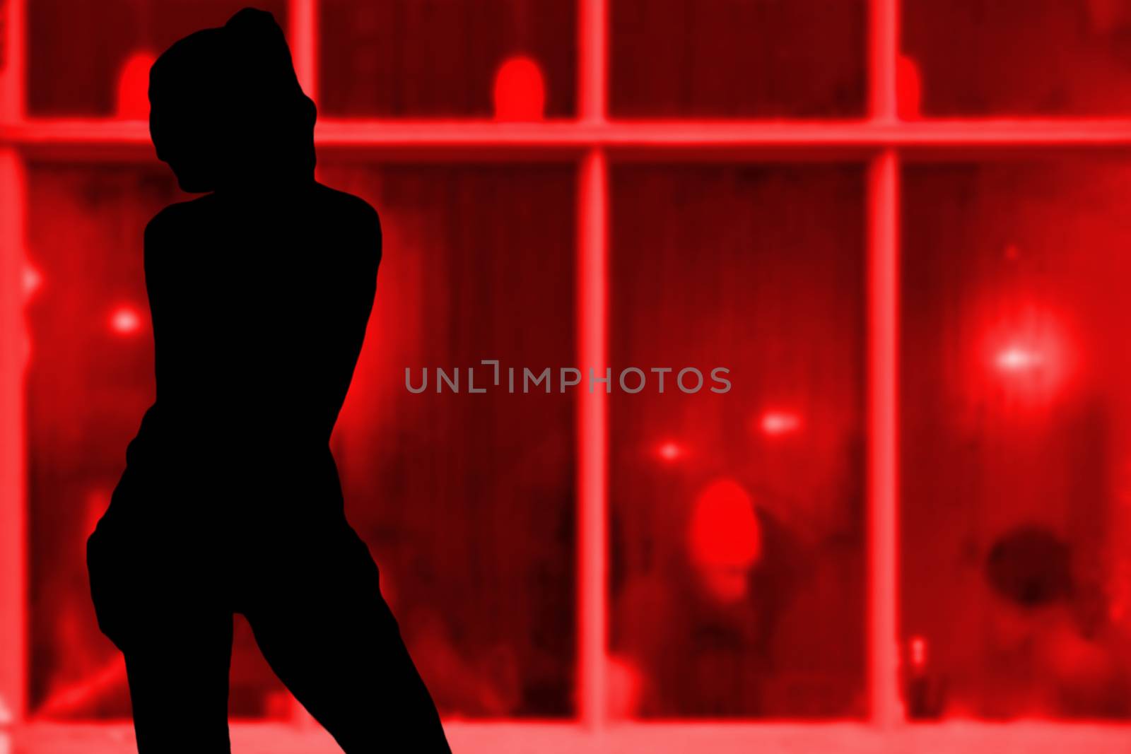 Sexy young girl silhouette standing in front of a red window hooker concept