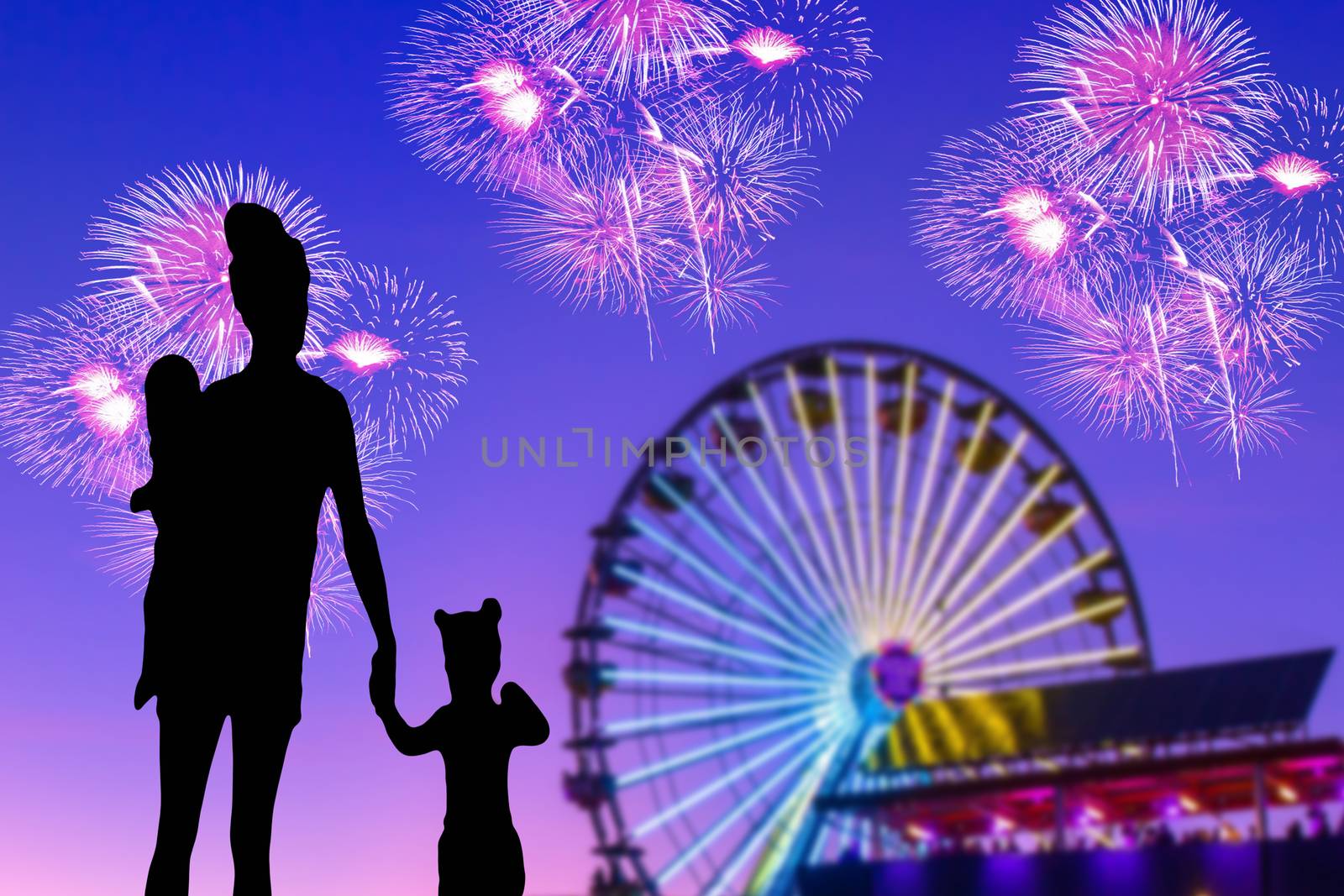 Silhouette of a family at the theme park with fireworks a mother with her little girl and baby