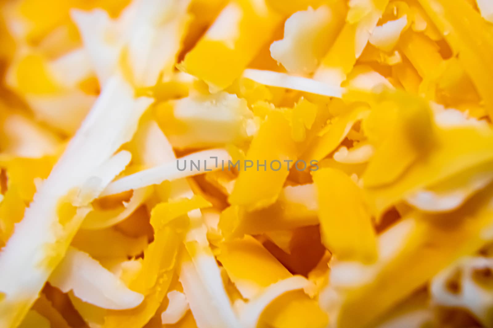 A close-up view of shredded farmer's marble cheddar cheese, showing the detail and color of the food.
