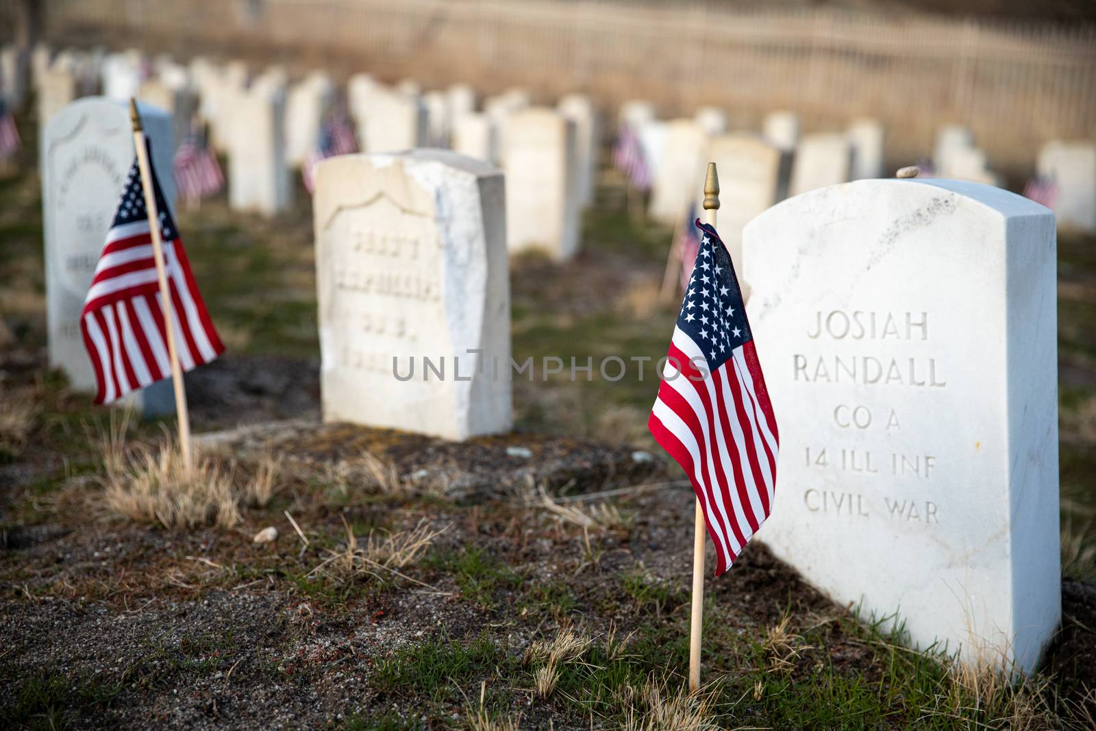 flags in front of the headstones of fallen soldiers