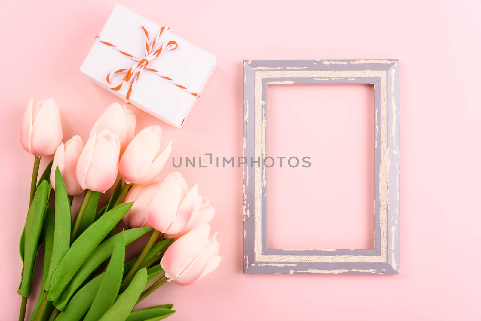 Happy Women's Day, Mother's Day concept. top view flat lay photo frame and Tulip flower on pink background, copy space for your text