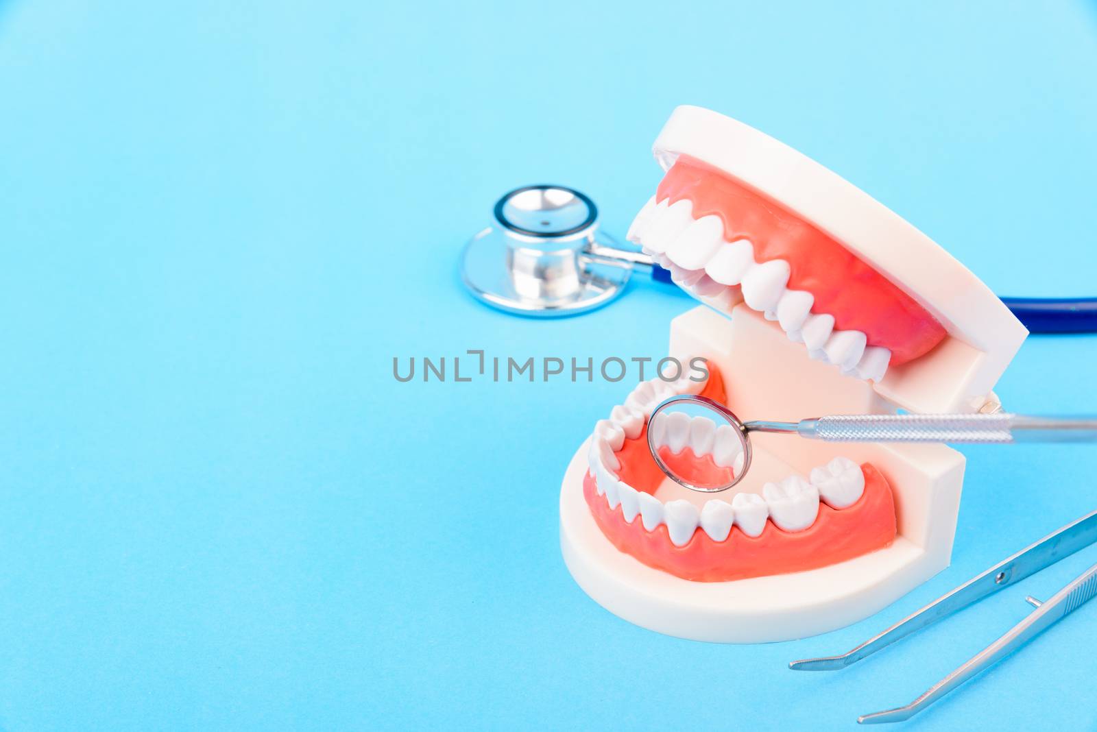 Dental Hygiene Health Concept, White tooth and Dentist tools for dental care on blue background