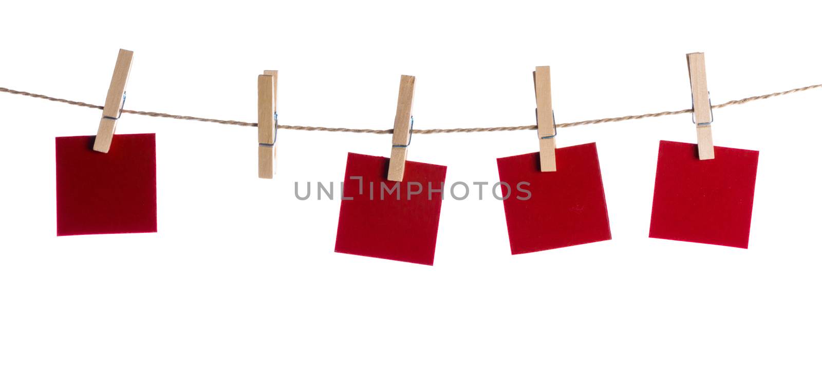 Set of four red blank paper notes held on a string with clothespins isolated on white background