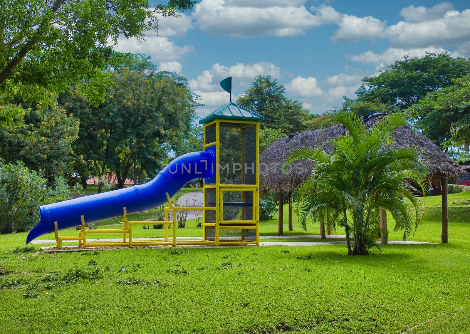 A park playground with a blue sliding board.