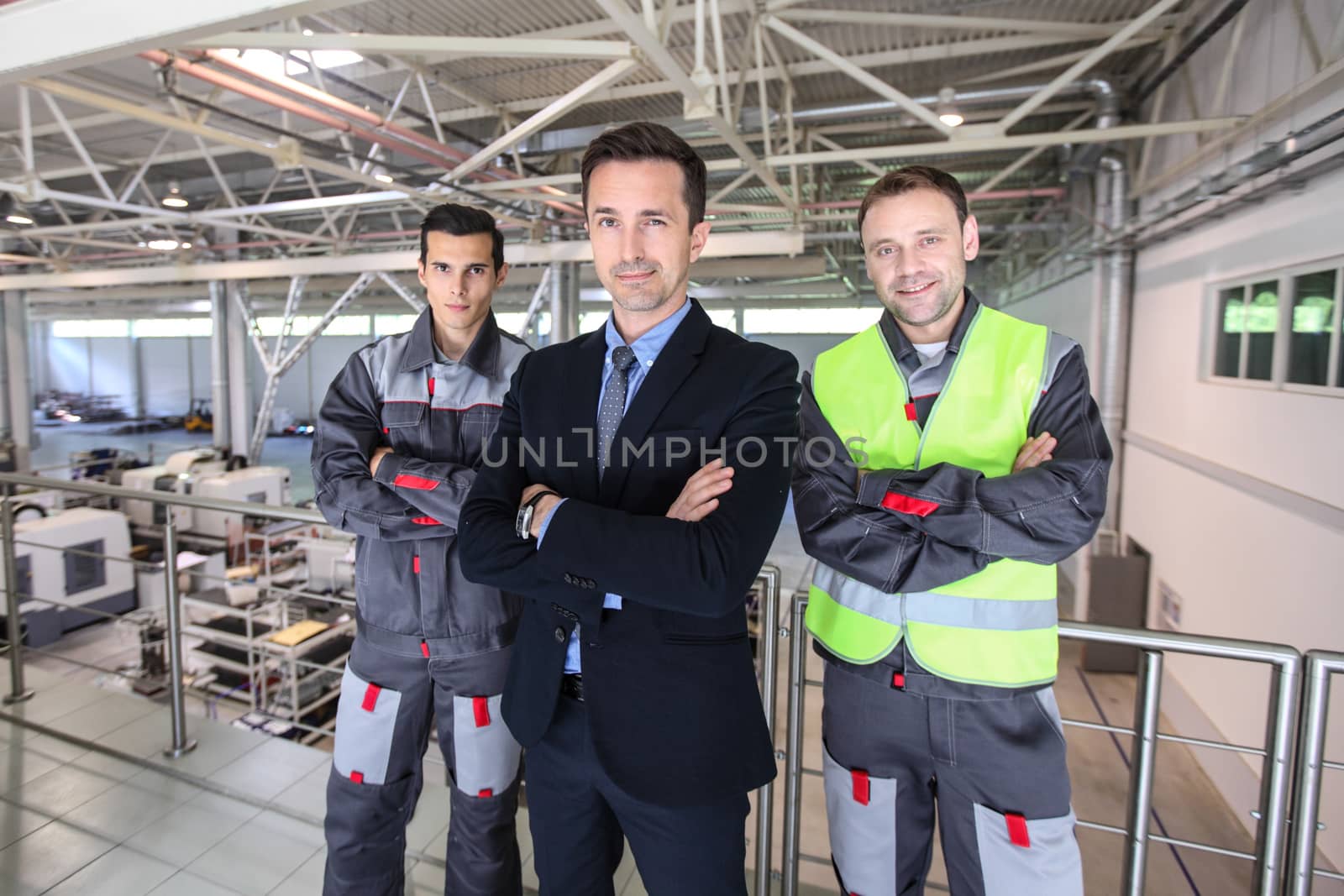 Portrait of business man and workers at factory teamwork cooperation concept