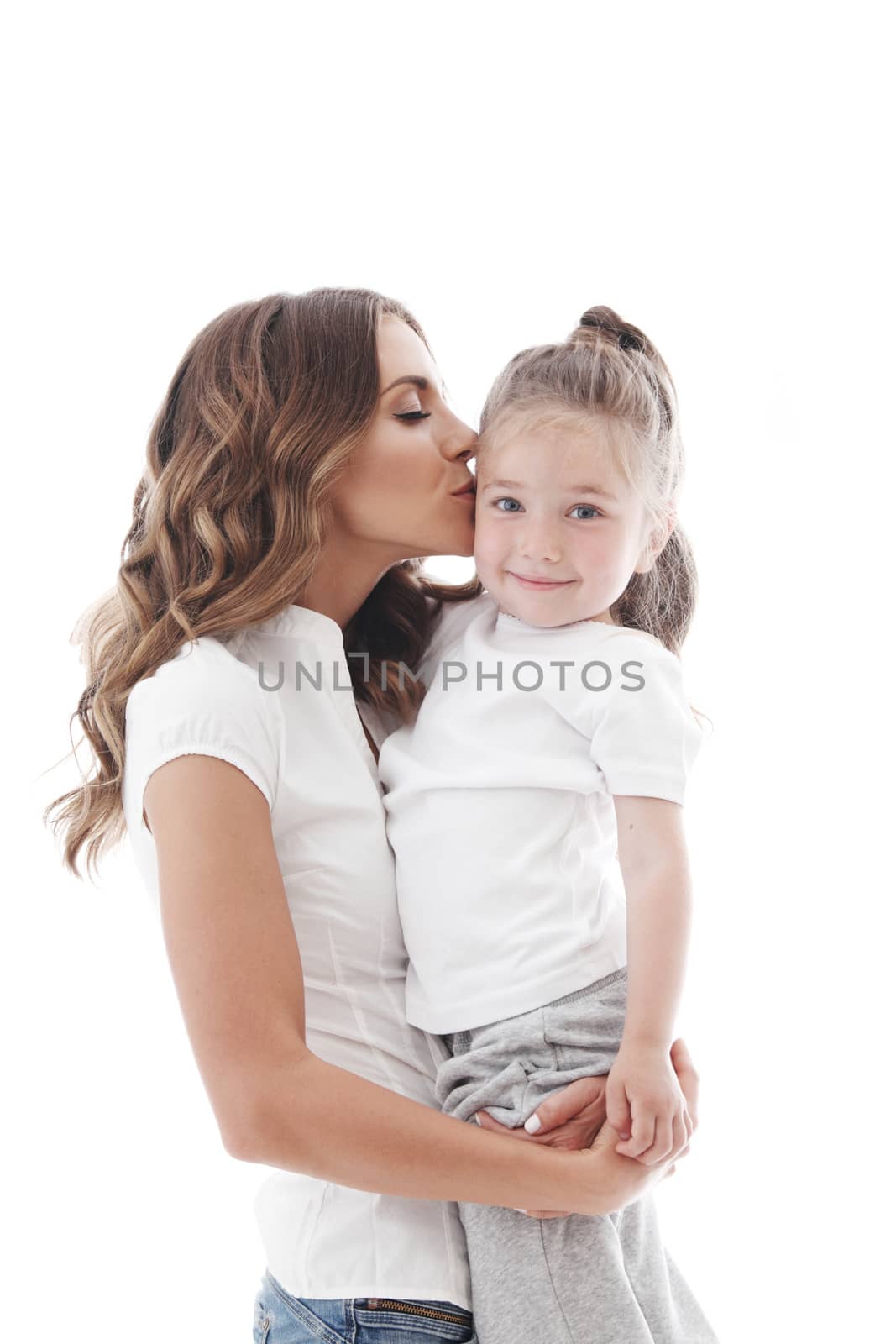 Mother kisses her daughter isolated on white background