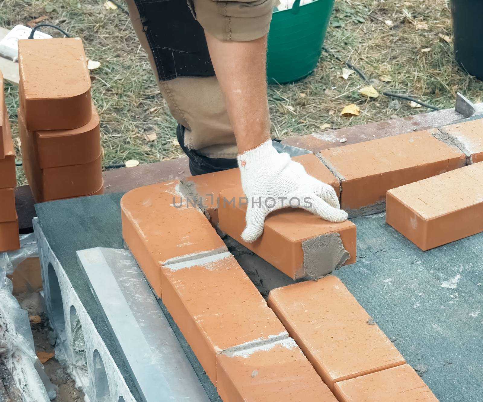 A man builds a brick wall. Brick put on the solution. Construction of a brick house.