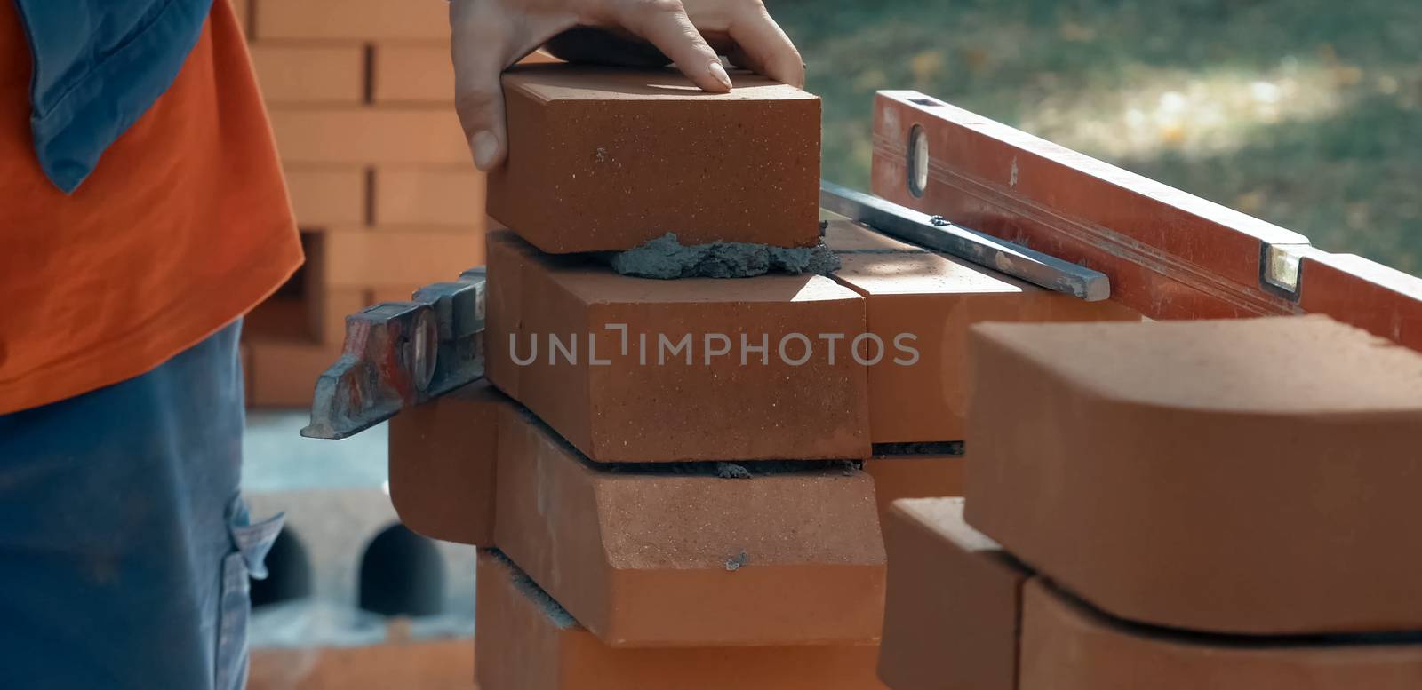 A man builds a brick wall. Brick put on the solution. Construction of a brick house.