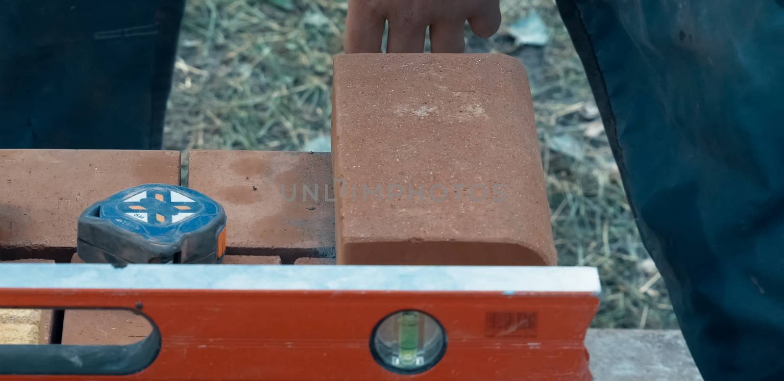 Measuring and marking bricks during the construction of the house.