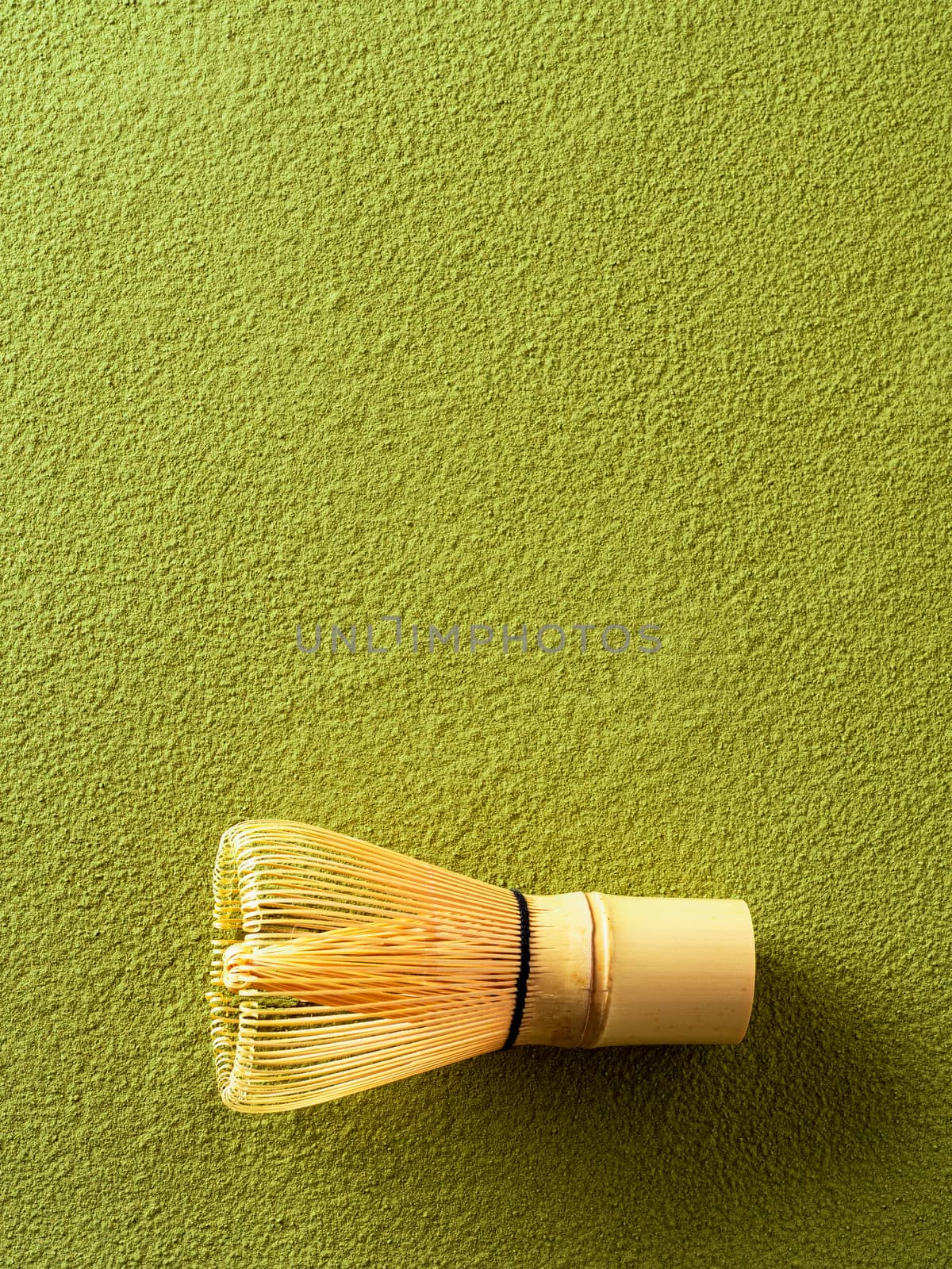 Powdered green tea Matcha background and bamboo whisk Chasen. Copy space for text or design. Vertical