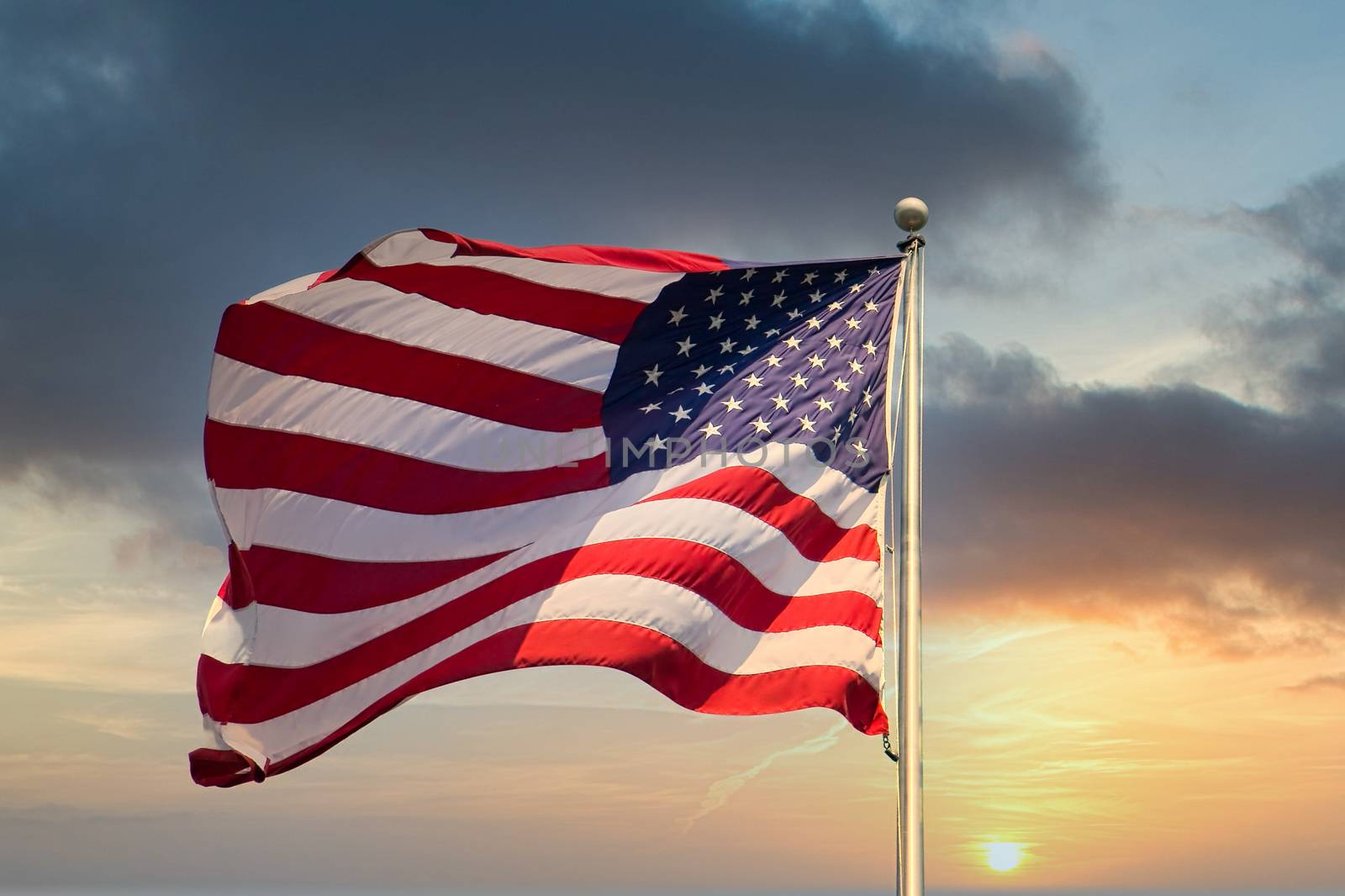 An American flag waving in the wind against a blue sky