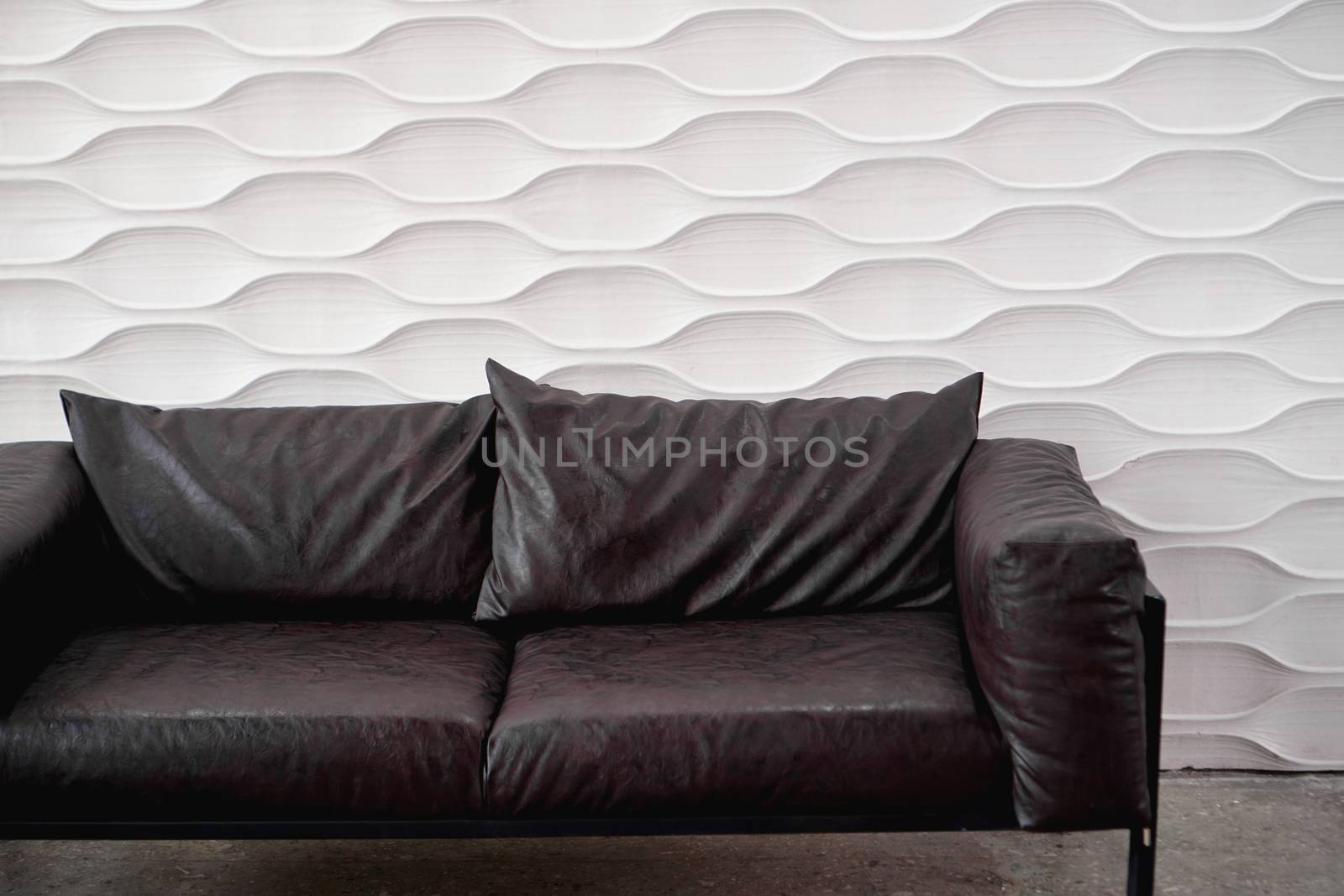 Black leather sofa on white background in studio by natali_brill
