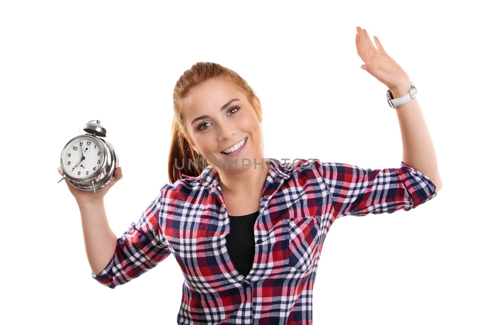 Time concept. Beautiful smiling young girl in casual clothes holding an old fashioned alarm clock with raised arms, isolated on white background.