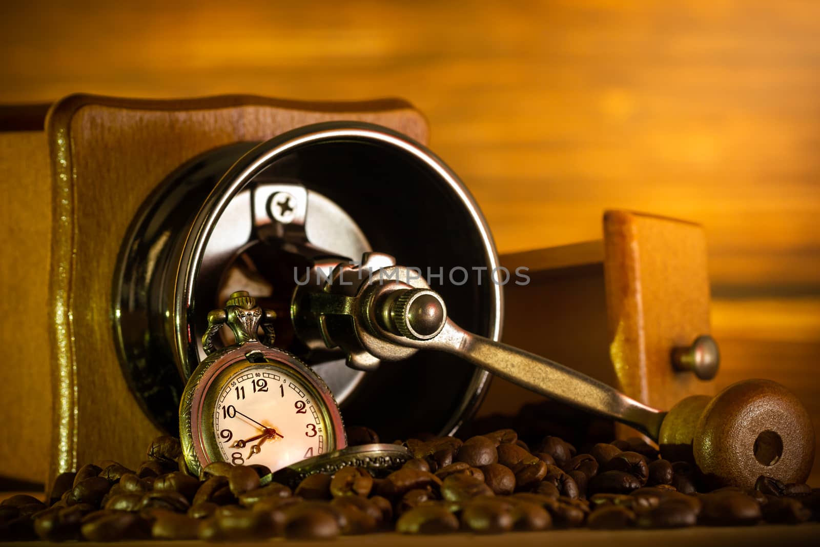 Coffee bean and pocket watch. Manual grinder on table in morning. Concept of coffee time.