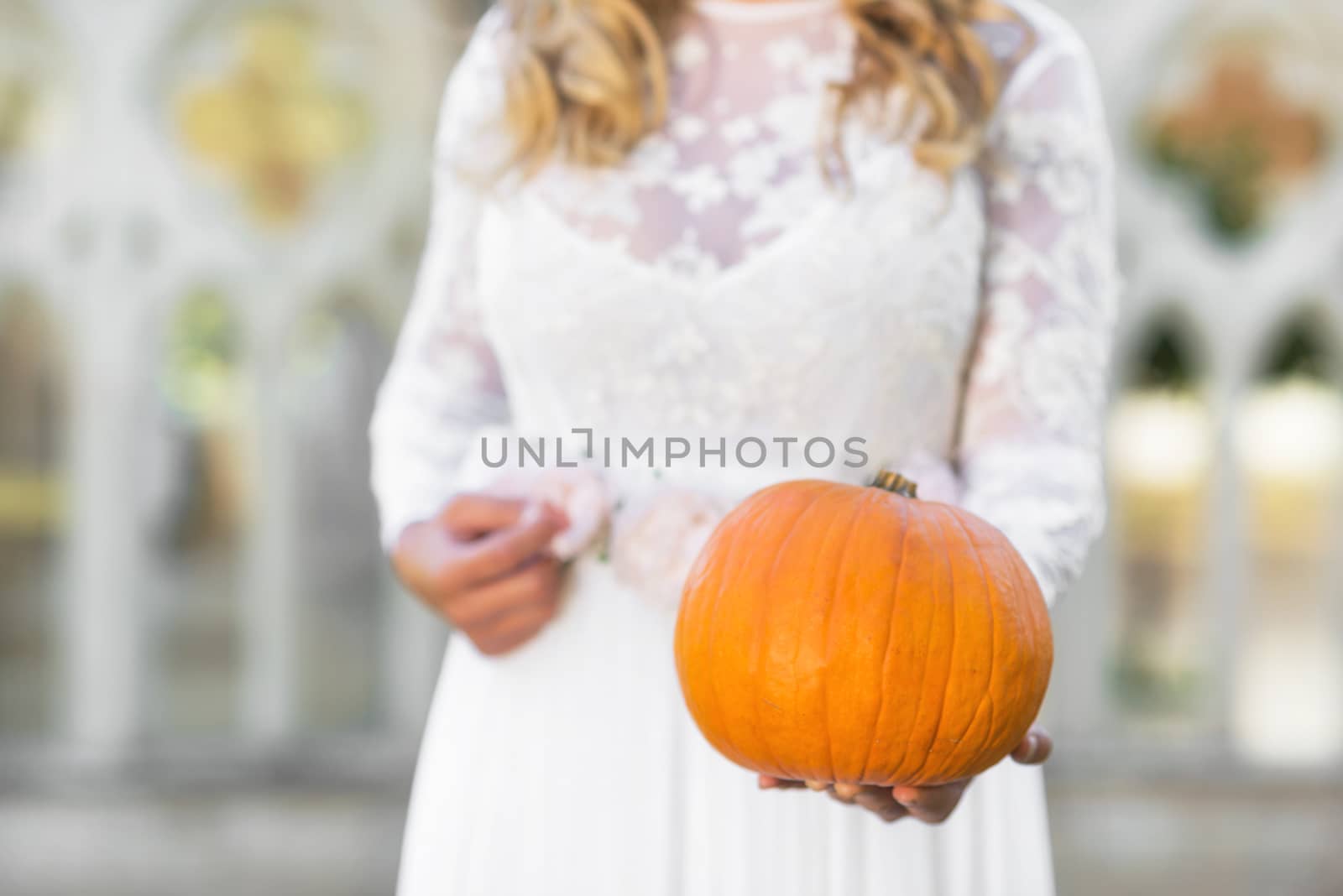 Bride holding pumpkin in her hands