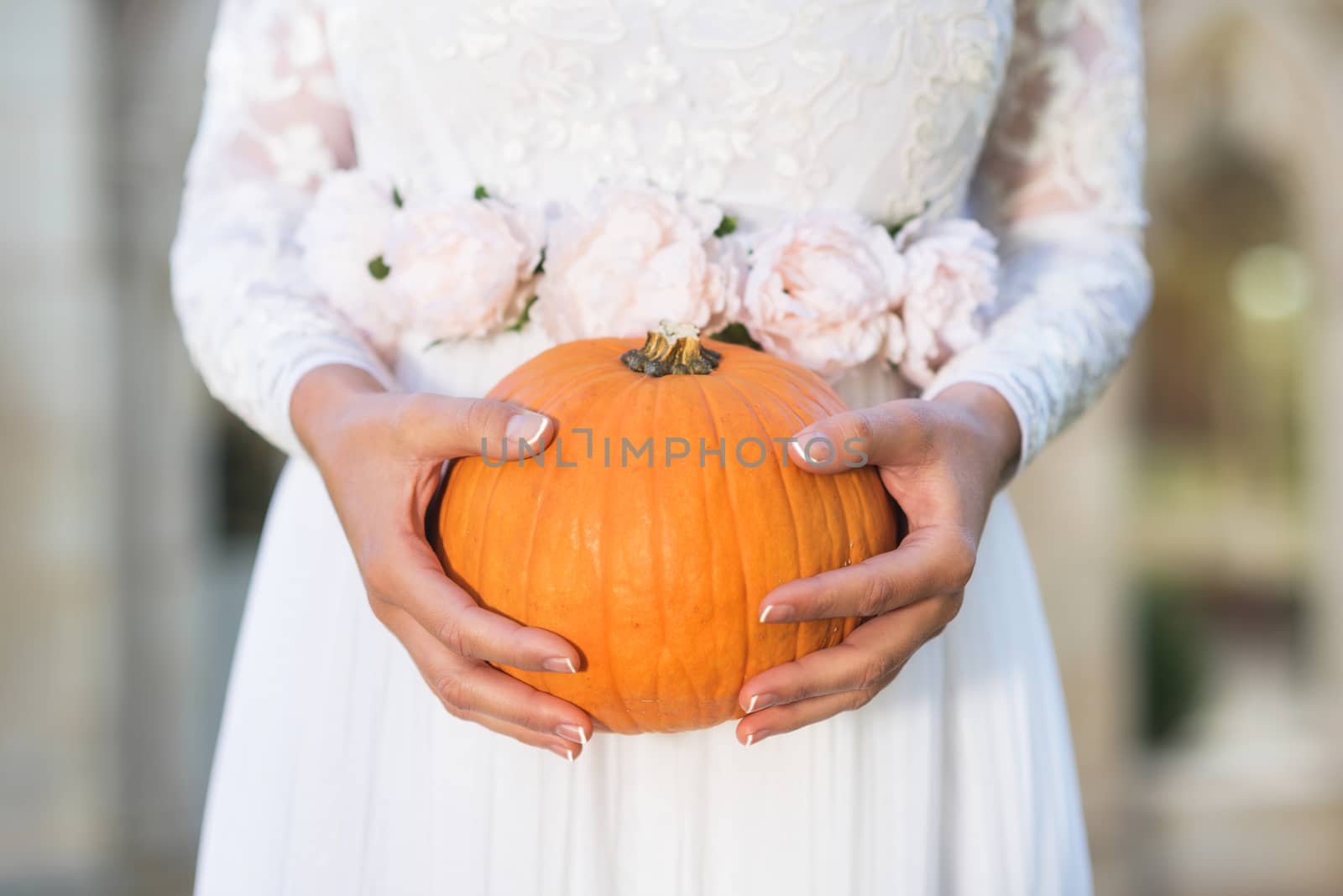 Bride holding pumpkin in her hands by HERRAEZ