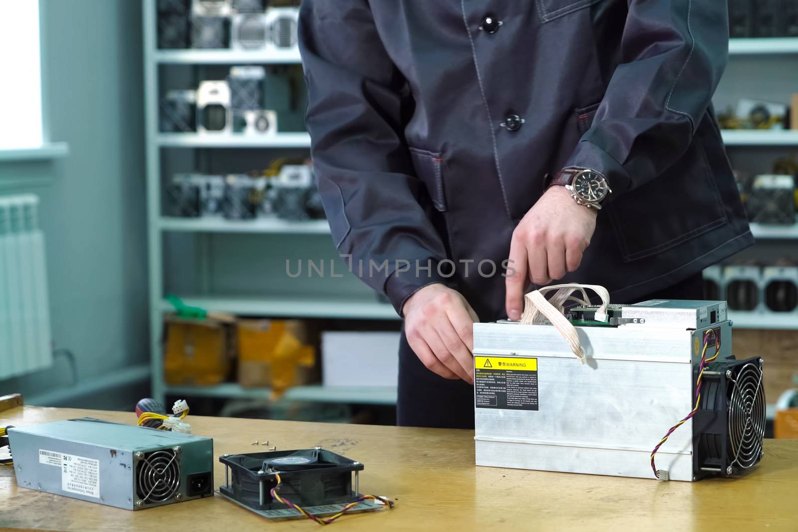 The repairman repairs the faulty equipment of the mining farm.