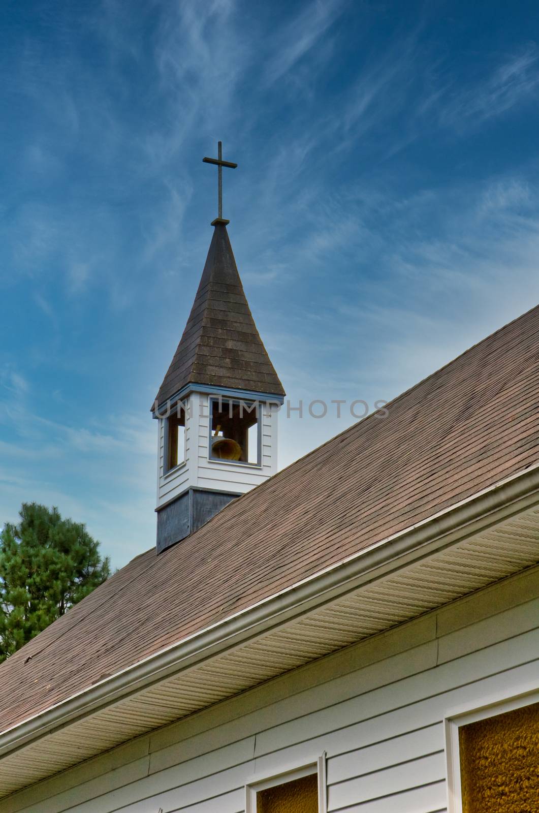 Steeple on an old white church and cloudy sky