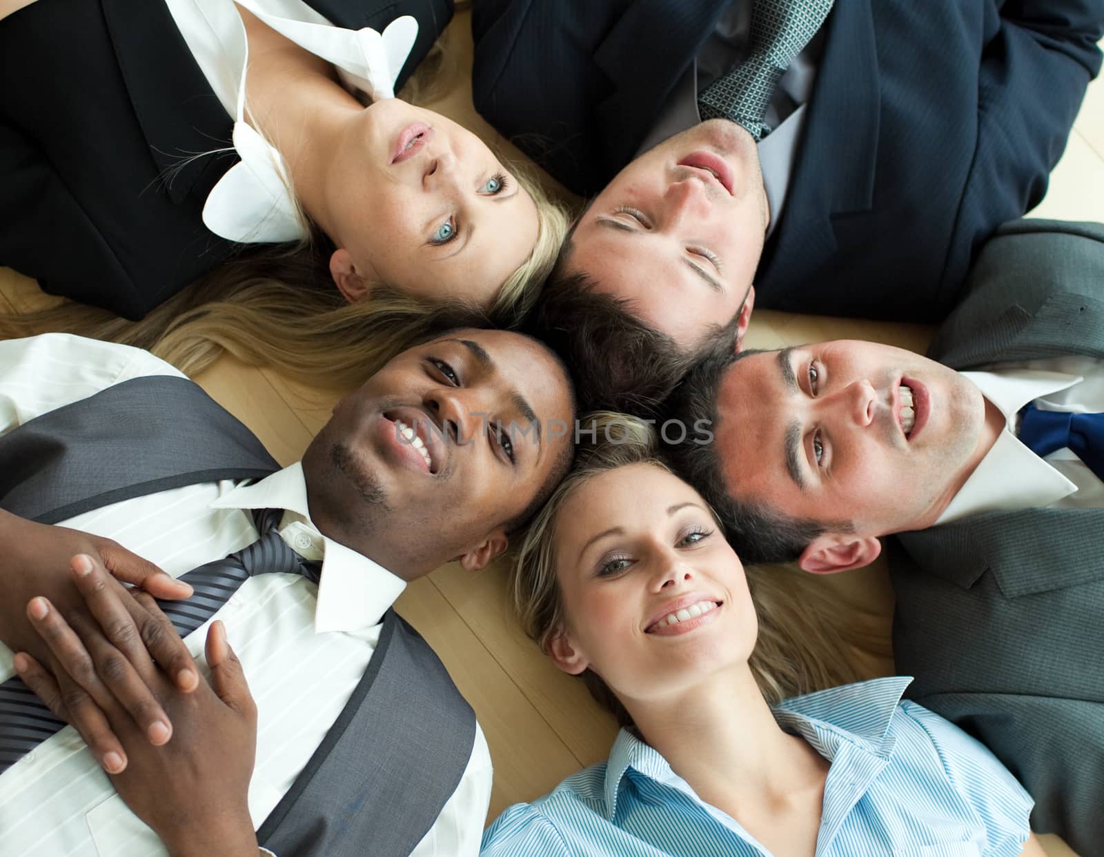 Closseup of Business people lying in a circle on the floor of the office