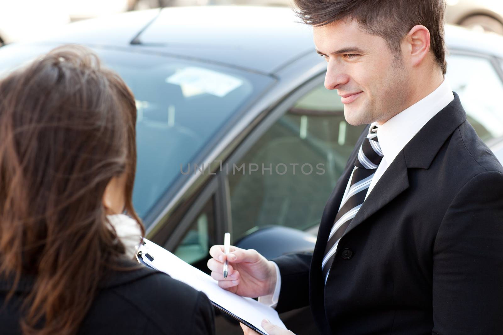 Positive businessman undersign a car contract outdoors