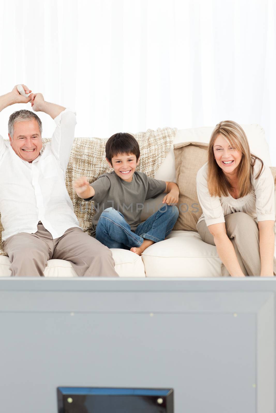 A little boy with his grandparents in the living room at home