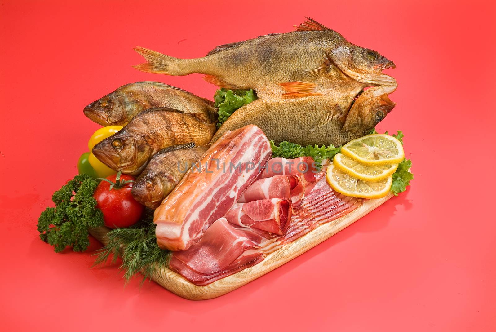 Smoked fish and vegetables on a studio background