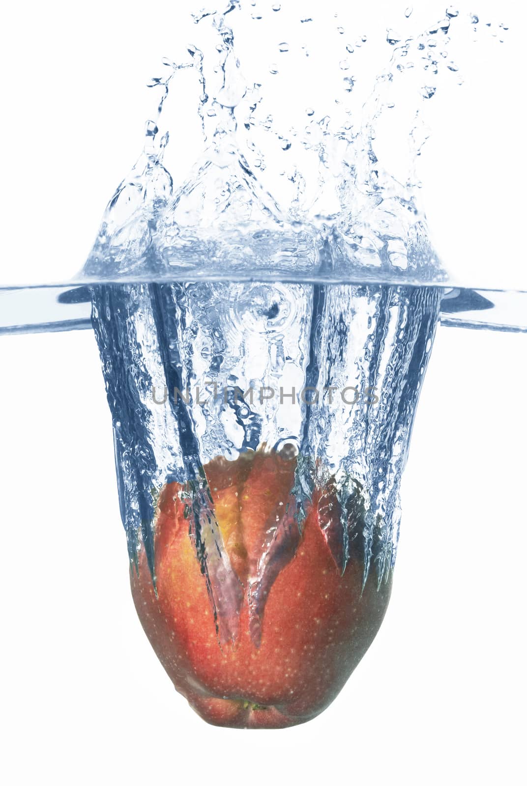 Apple falls deeply under water with a big splash. 