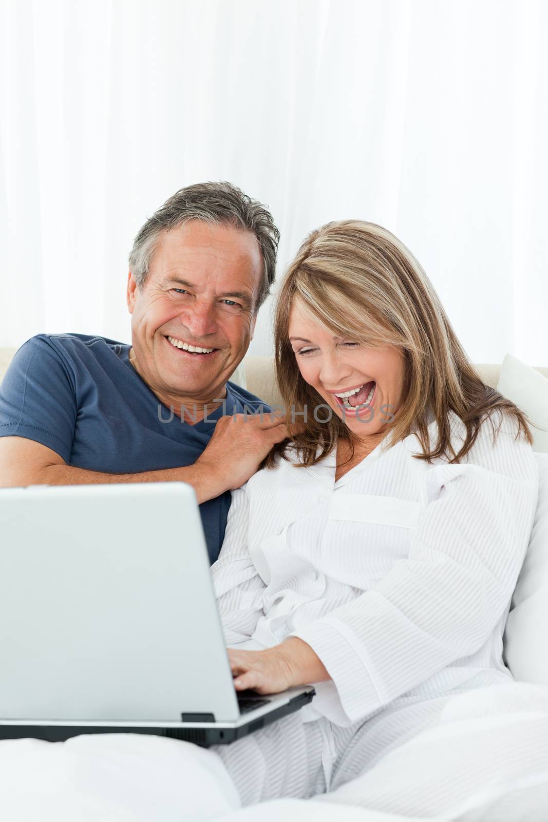 Mature lovers looking at their laptop by Wavebreakmedia
