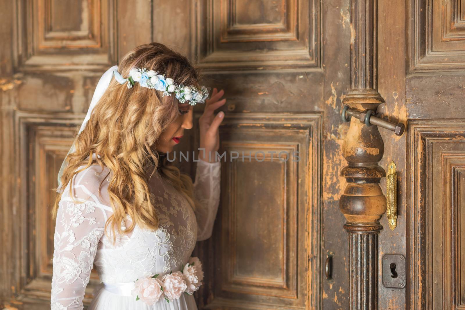 Beautiful bride portrait on old wooden door background by HERRAEZ