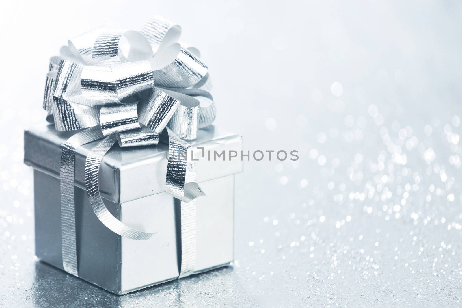 Decorated holiday gift on silver background
